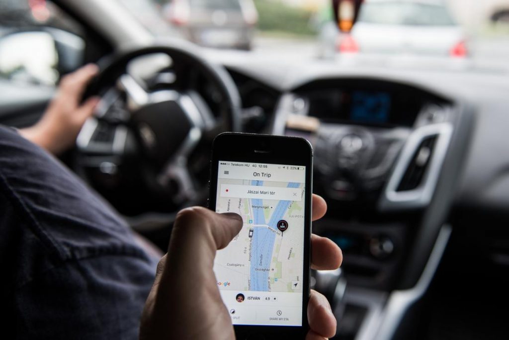 A passenger holds an Apple Inc. iPhone displaying the Uber Technologies Inc. car service taxi application (app) journey progress screen in this arranged photograph in Budapest, Hungary, on Wednesday, July 13, 2016. Uber will suspend its ride-hailing services in Hungary from July 24 following a government decision to pass a bill that allows authorities to block access to the mobile application and fine media promoting it. Photographer: Akos Stiller/Bloomberg via Getty Images
